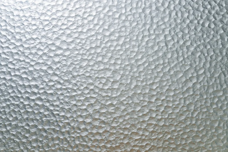 Frosted patterned glass surface filling the frame with a hexagonal texture
