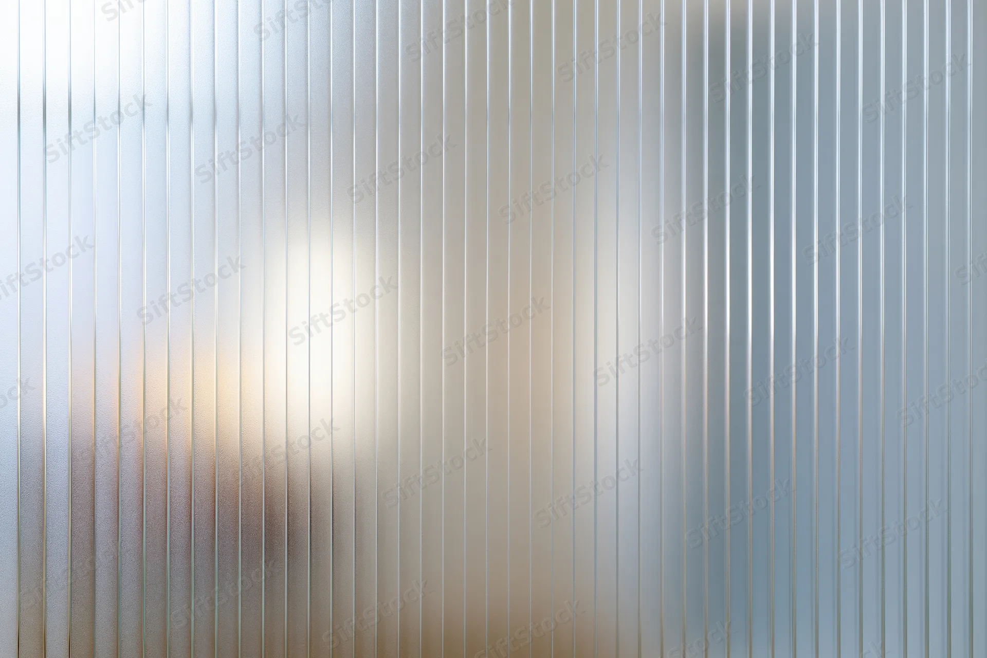 Ribbed frosted glass panel filling the frame with vertical lines and diffused light
