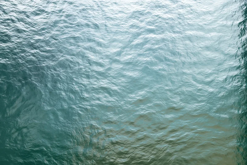Frosted glass panel with textured surface showing light ripples and translucent patterns in cool blue and green tones