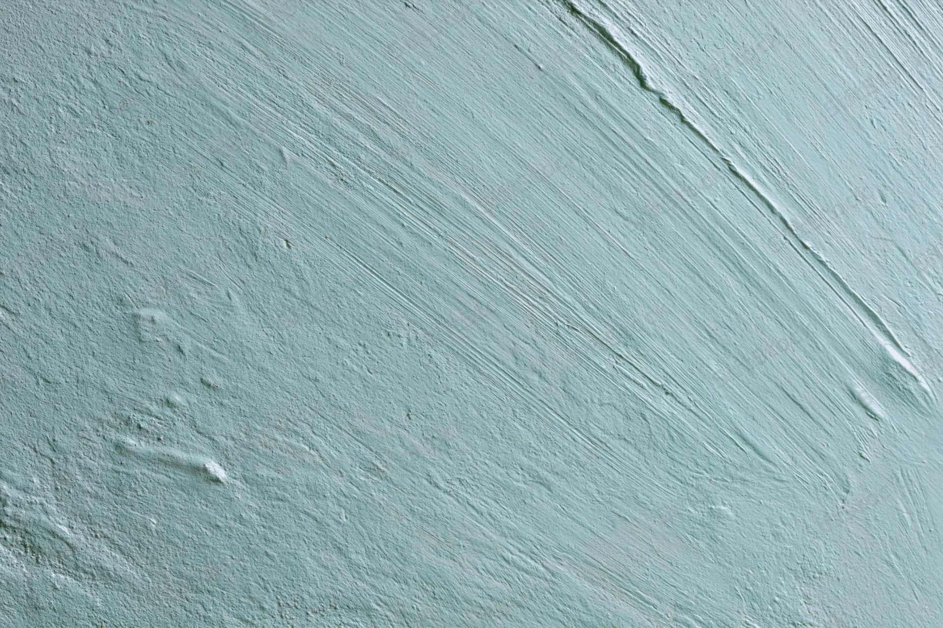 Close-up of matte painted concrete wall surface with visible brushstrokes and texture