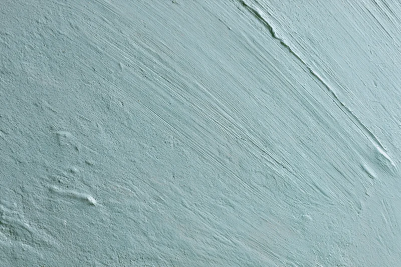 Close-up of matte painted concrete wall surface with visible brushstrokes and texture