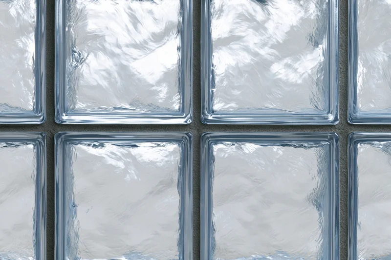 Close-up of a glass block wall arranged in a grid pattern with frosted translucent panels and gray mortar joints