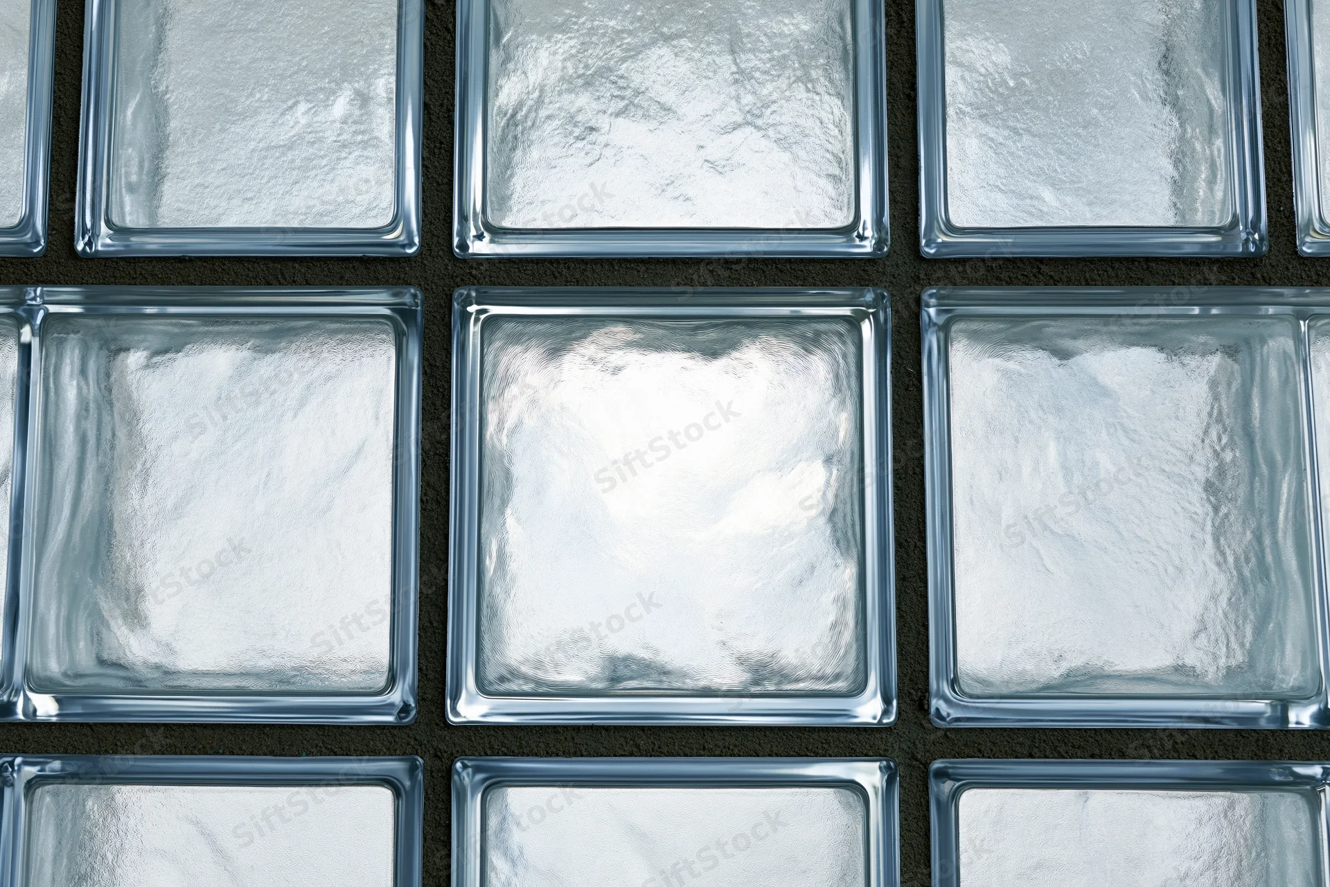 Glass blocks arranged in a grid pattern on a dark wall