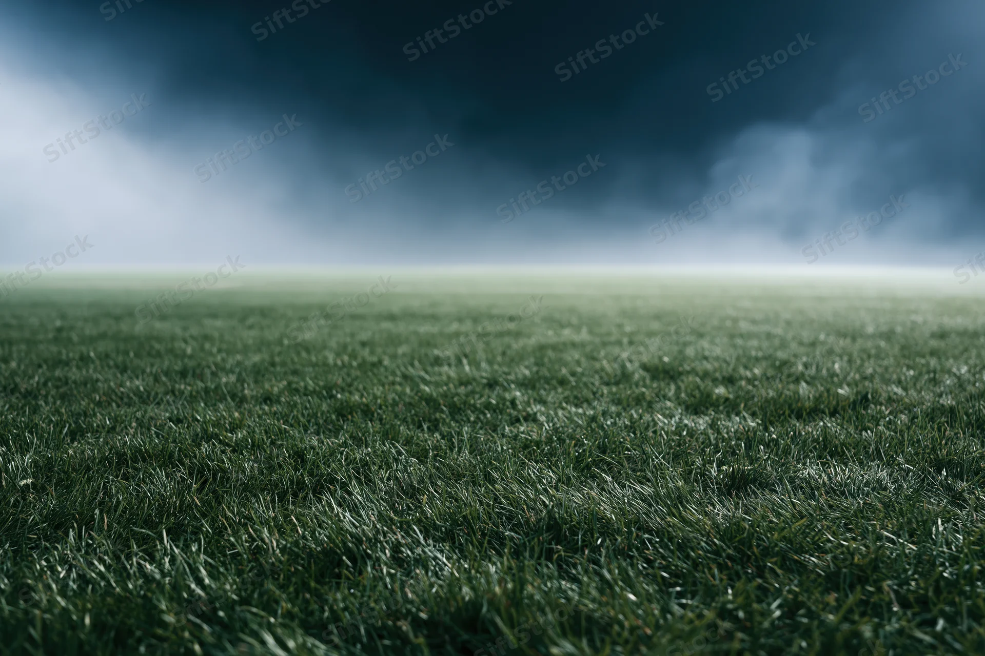 Close-up view of a professional football pitch under stormy skies