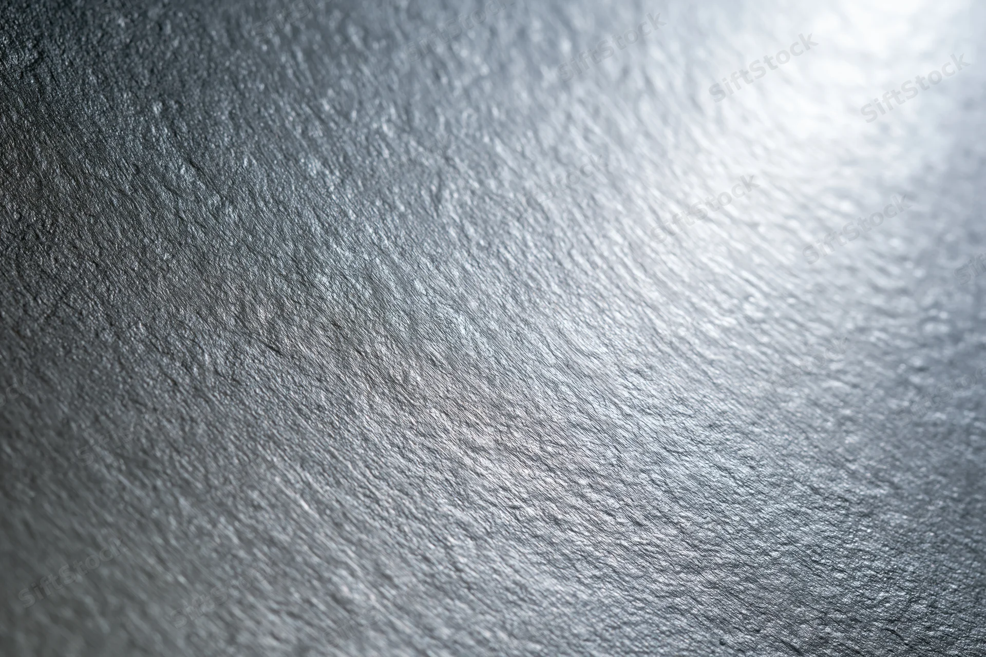 Close-up of brushed silver metal surface showing fine texture and reflective finish