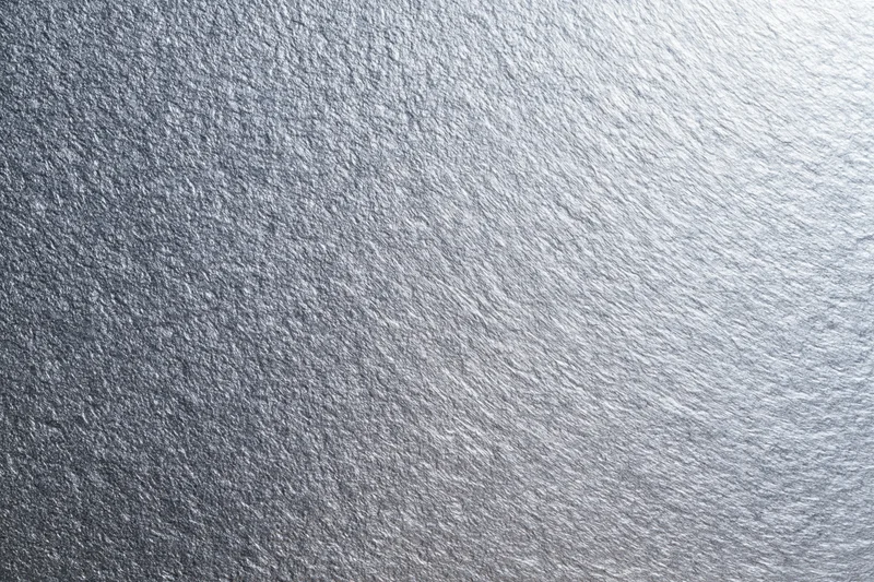 Close-up of brushed metallic silver surface showing fine texture and reflective grain