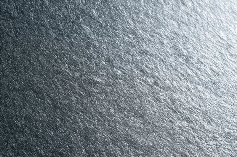 Close-up of brushed silver metal surface showing fine texture and reflective grain