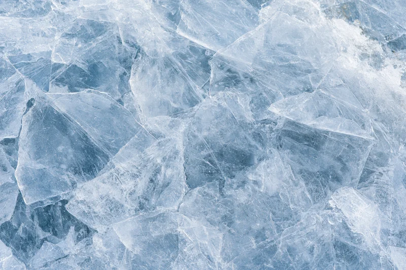 Close-up of fractured ice shards forming a textured frozen surface