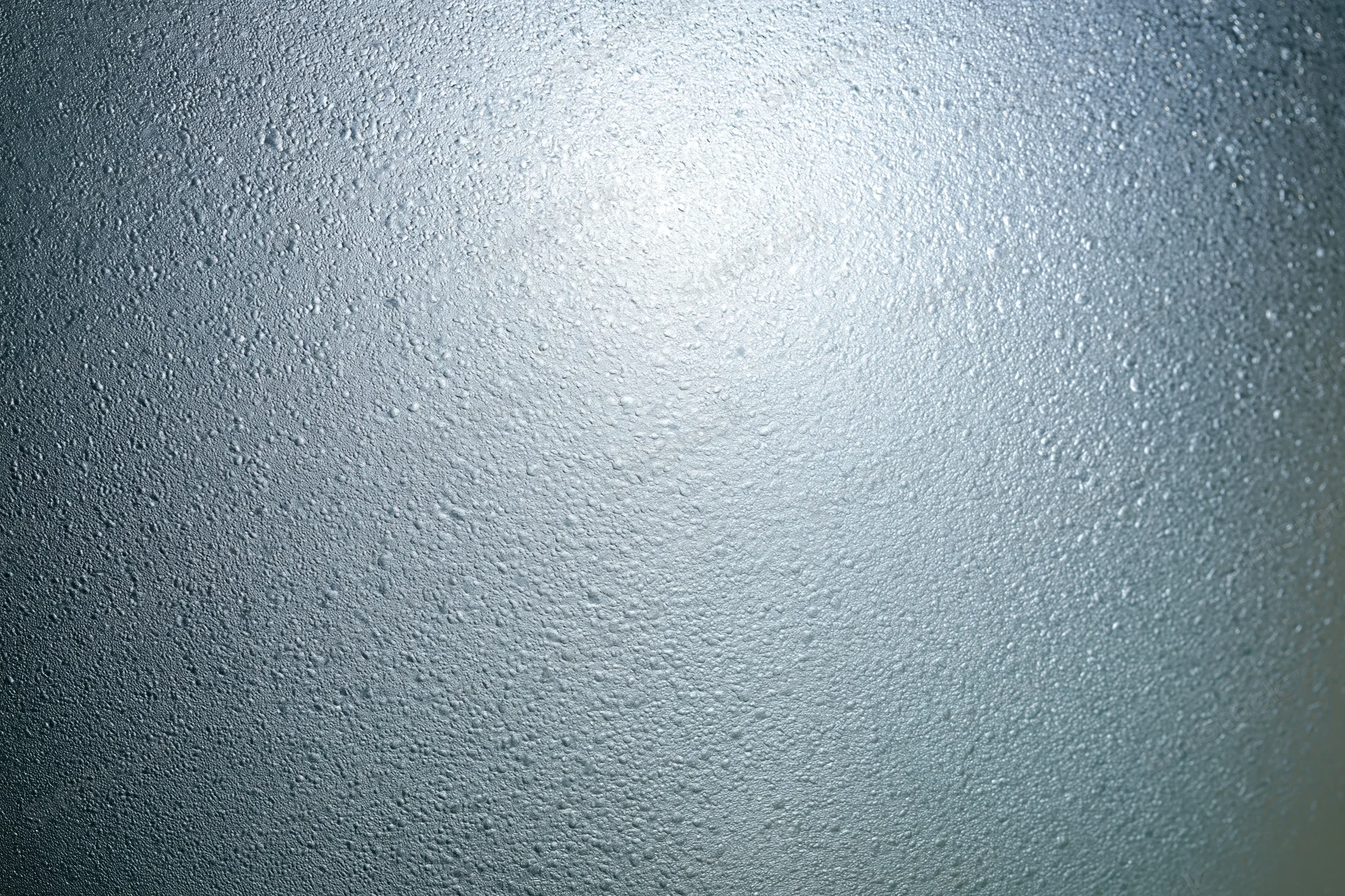 Fogged glass surface covered in fine water droplets from condensation