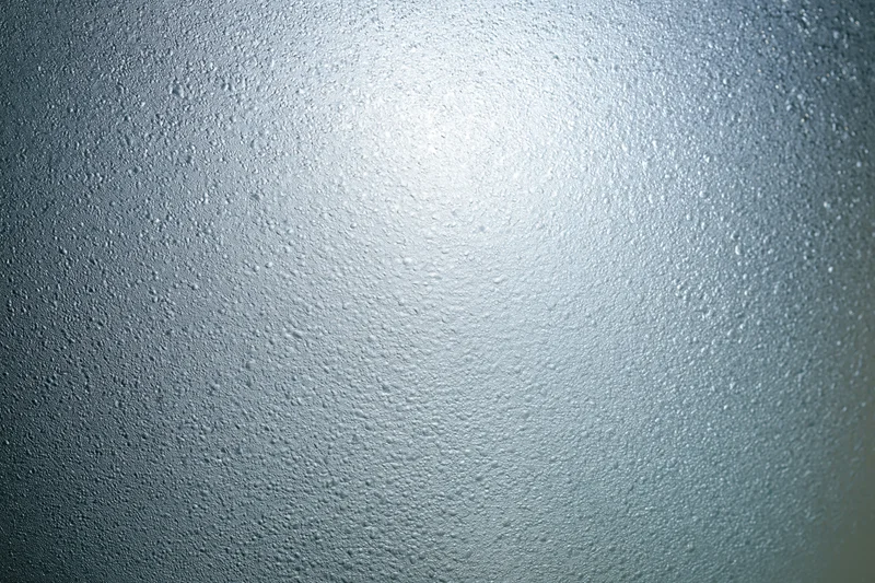 Fogged glass surface covered in fine water droplets from condensation
