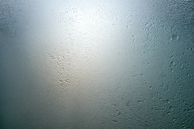 Fogged glass surface covered in fine water droplets and condensation