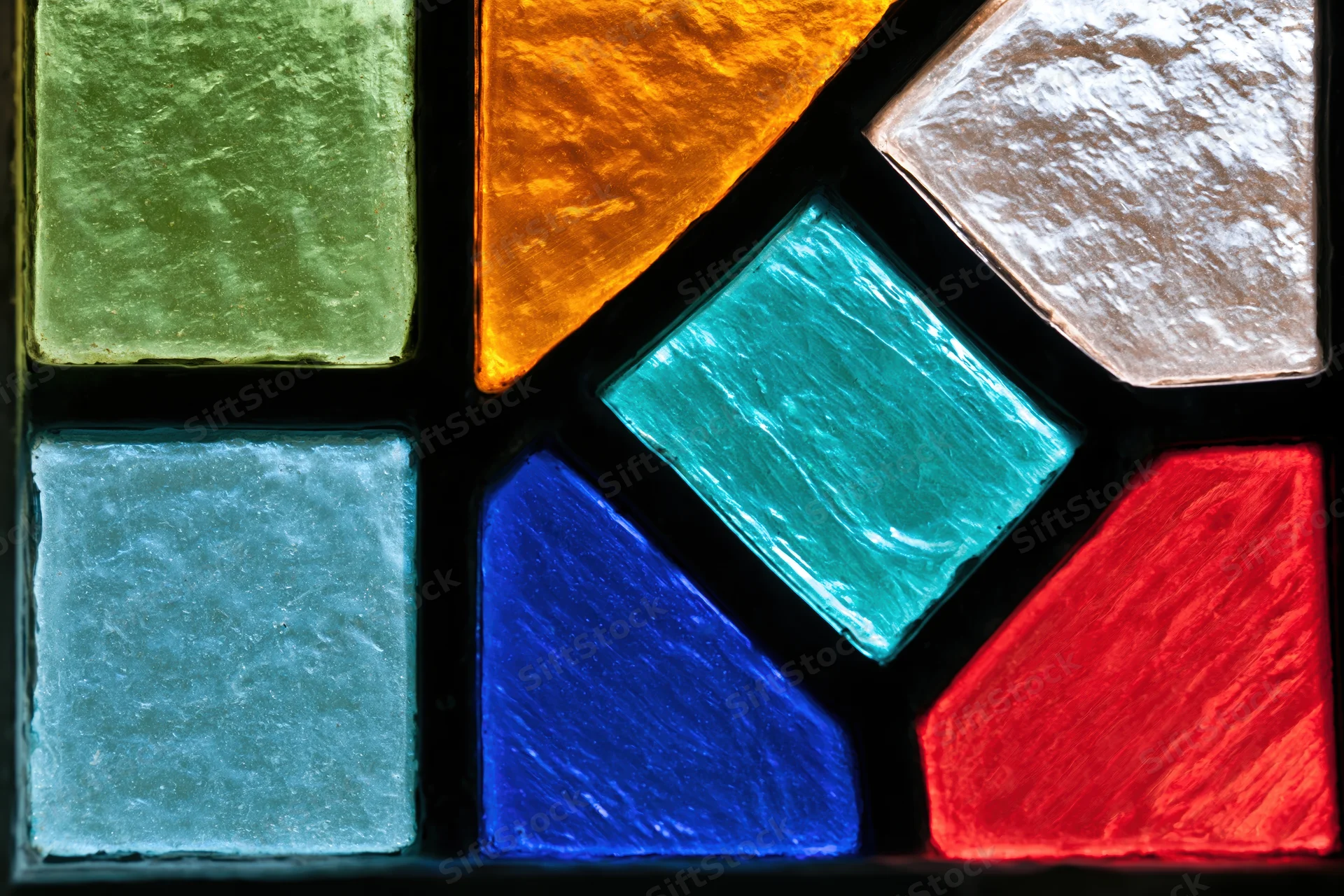 Close-up of a geometric stained glass window panel with vibrant colored glass pieces arranged in an abstract pattern