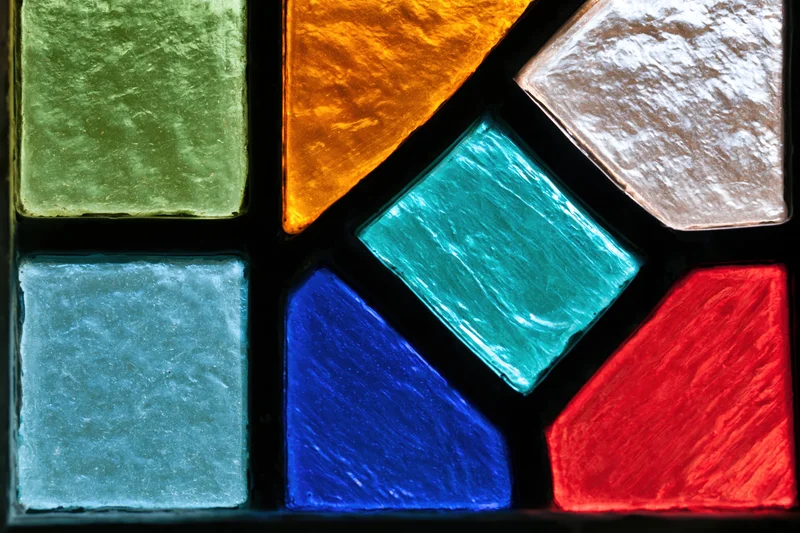 Close-up of a geometric stained glass window panel with vibrant colored glass pieces arranged in an abstract pattern