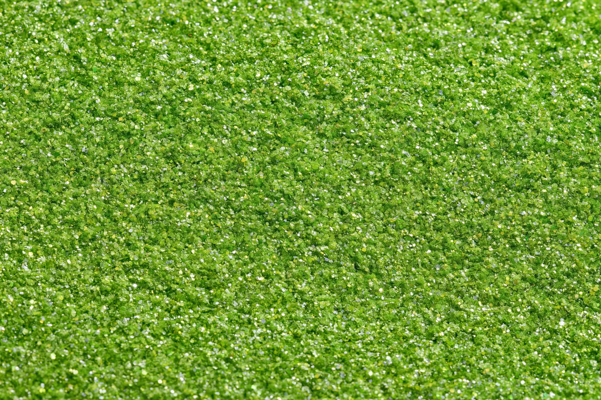 Bright green glitter texture filling the frame in a close-up macro view