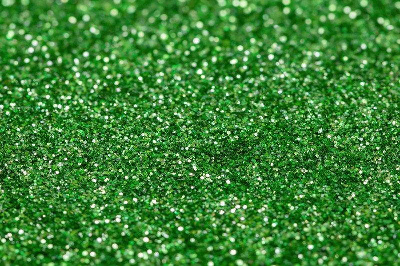 Bright green glitter texture filling the frame in a close-up macro view