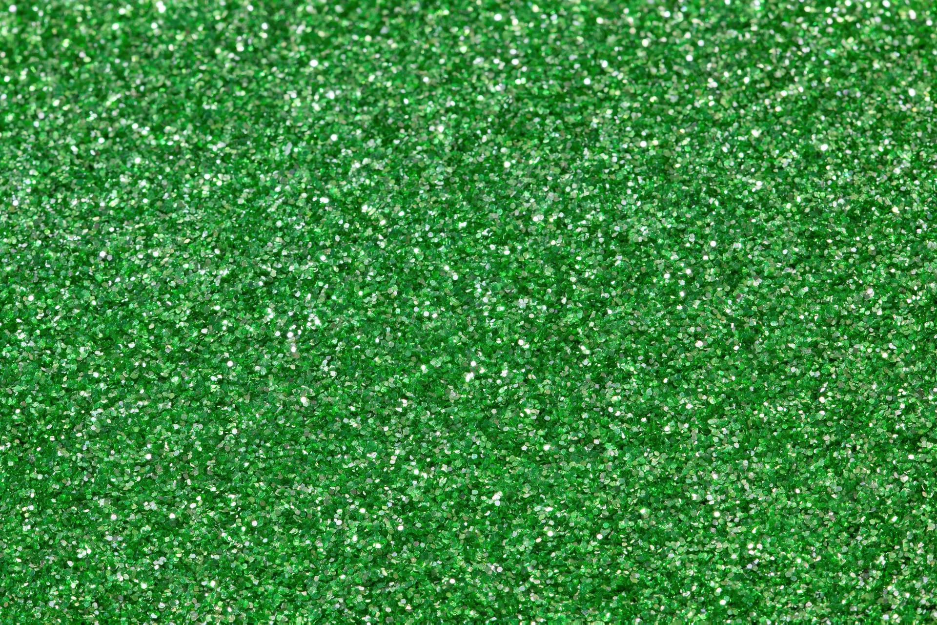 Bright green glitter texture filling the frame in a close-up macro view