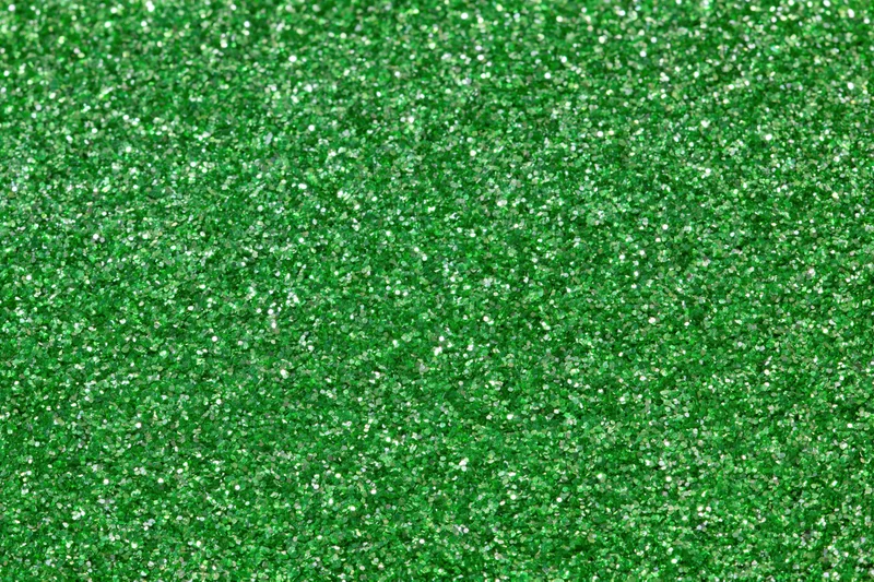 Bright green glitter texture filling the frame in a close-up macro view