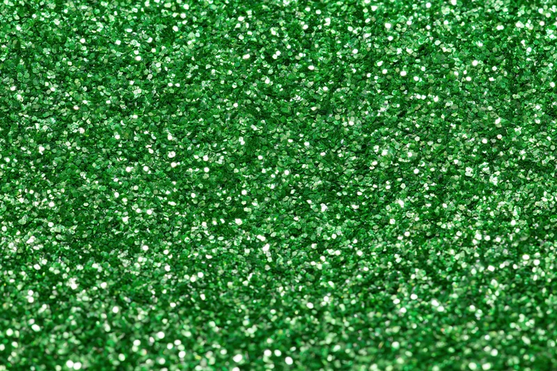 Bright green glitter texture filling the frame in a close-up macro view