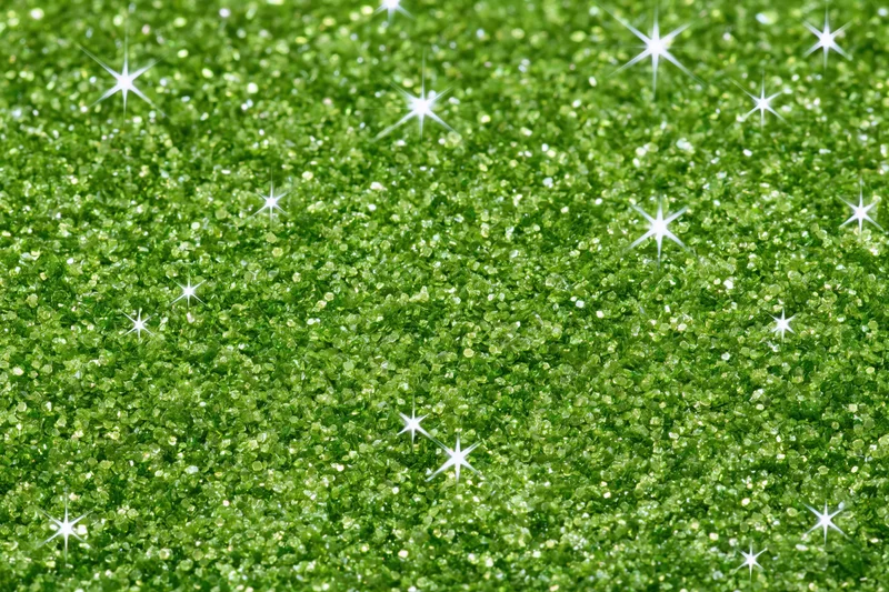 Bright green glitter texture with sparkling highlights filling the frame