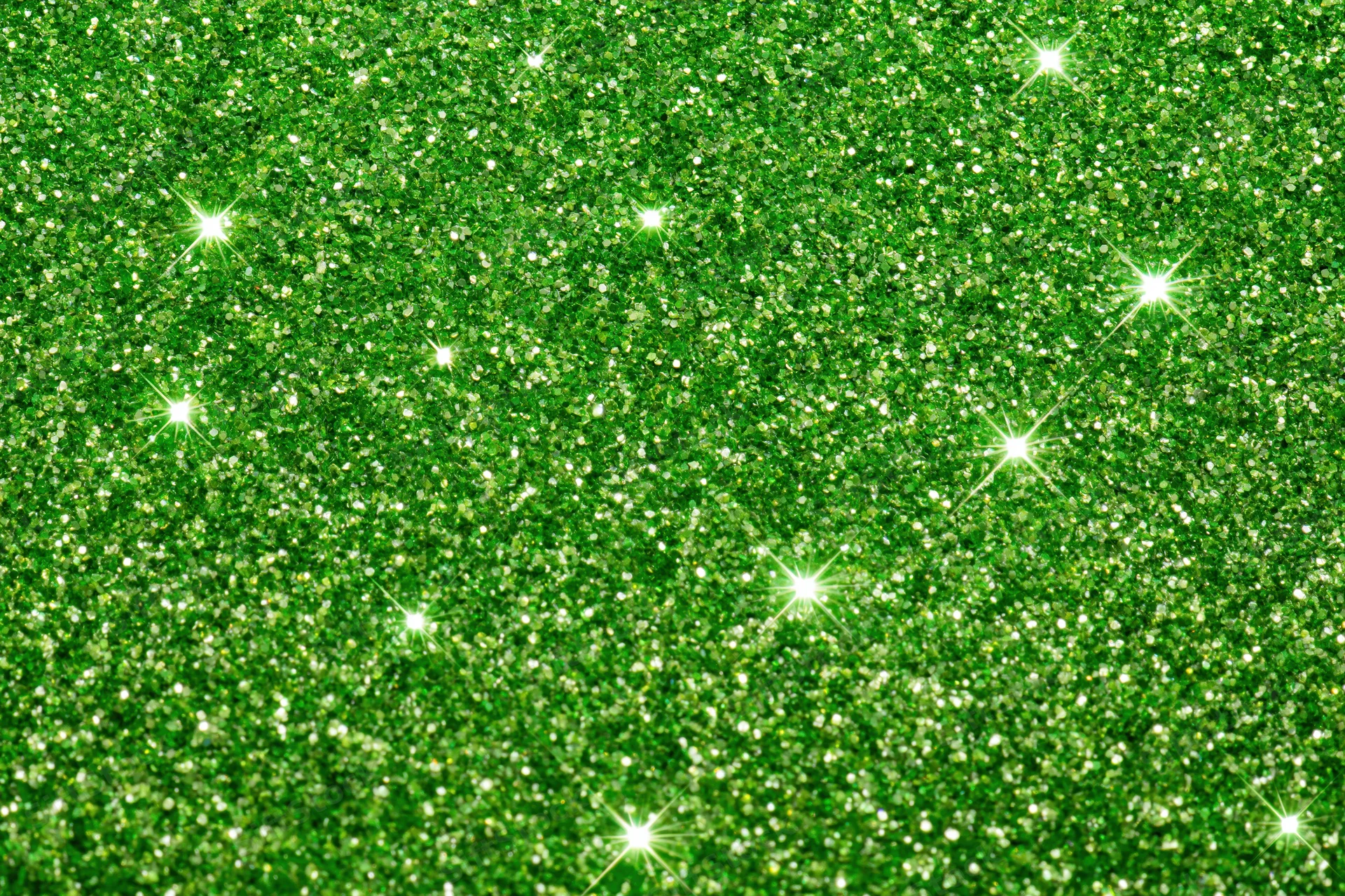 Bright green glitter texture with sparkling highlights filling the frame
