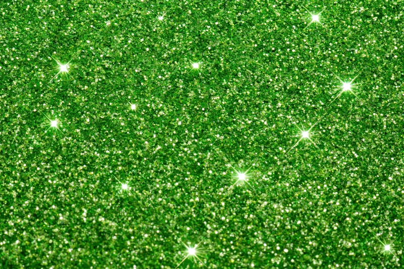Bright green glitter texture with sparkling highlights filling the frame