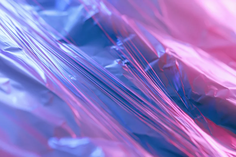 Crinkled metallic foil with iridescent sheen in pink and blue hues
