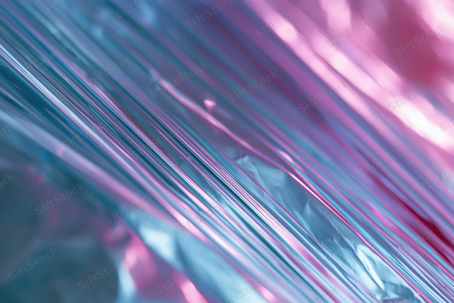 Crinkled metallic foil with iridescent pink and blue shimmer in close-up macro view