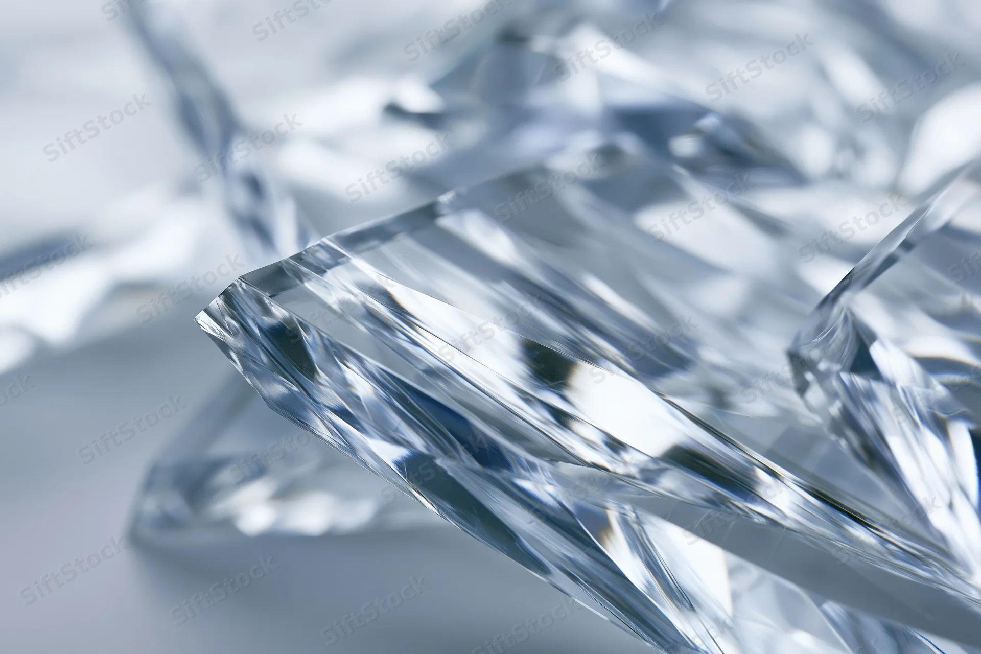 Fractured glass shard with sharp edges and light reflections on a smooth surface