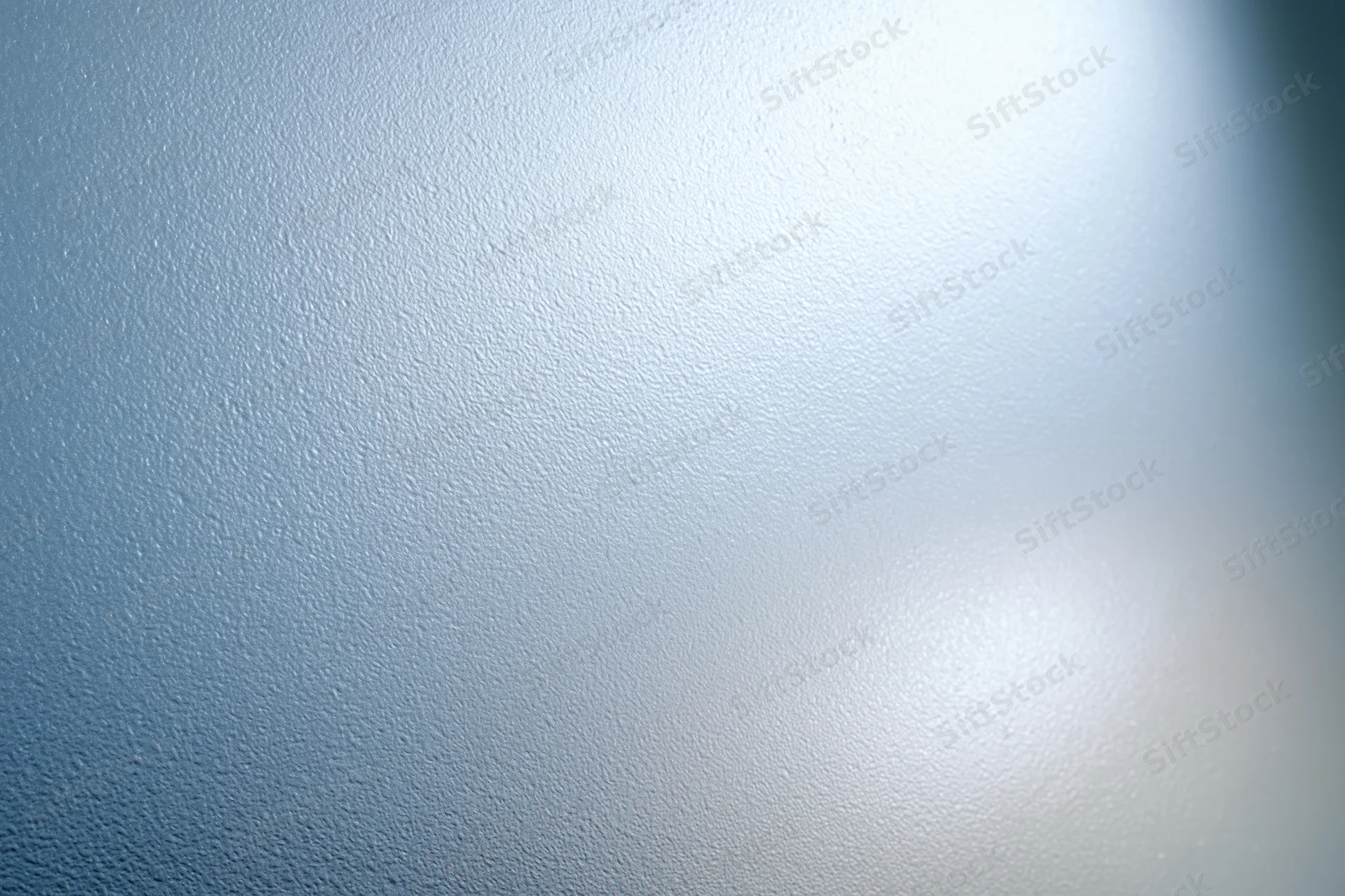 Frosted glass surface with smooth texture and light reflection filling the frame
