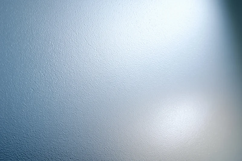 Frosted glass surface with smooth texture and light reflection filling the frame