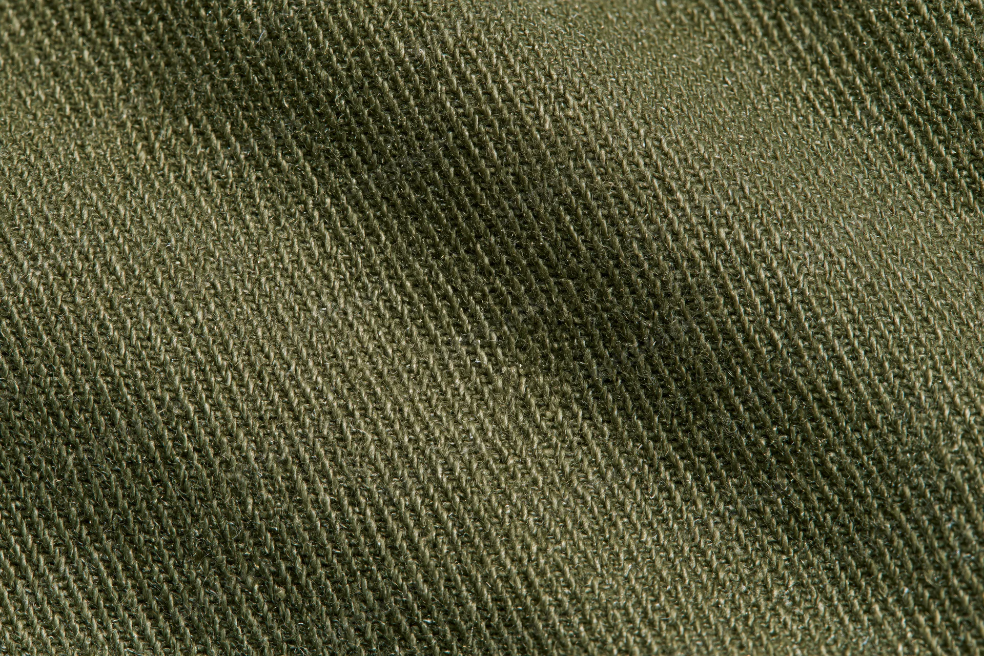 Close-up of olive green twill fabric showing diagonal weave pattern and texture