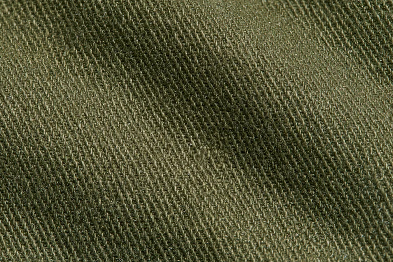 Close-up of olive green twill fabric showing diagonal weave pattern and texture