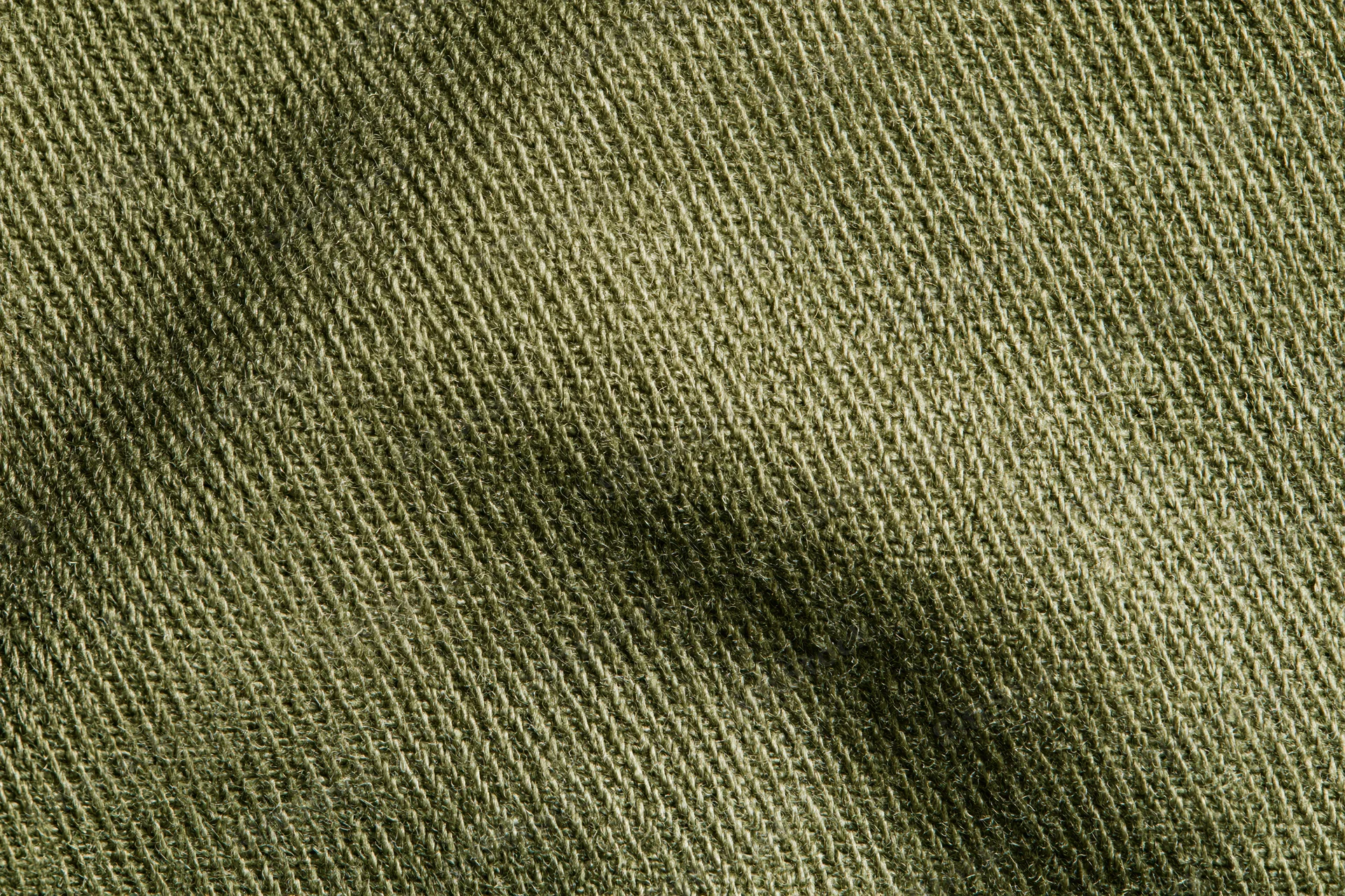 Close-up of olive green twill fabric showing diagonal weave pattern filling the frame