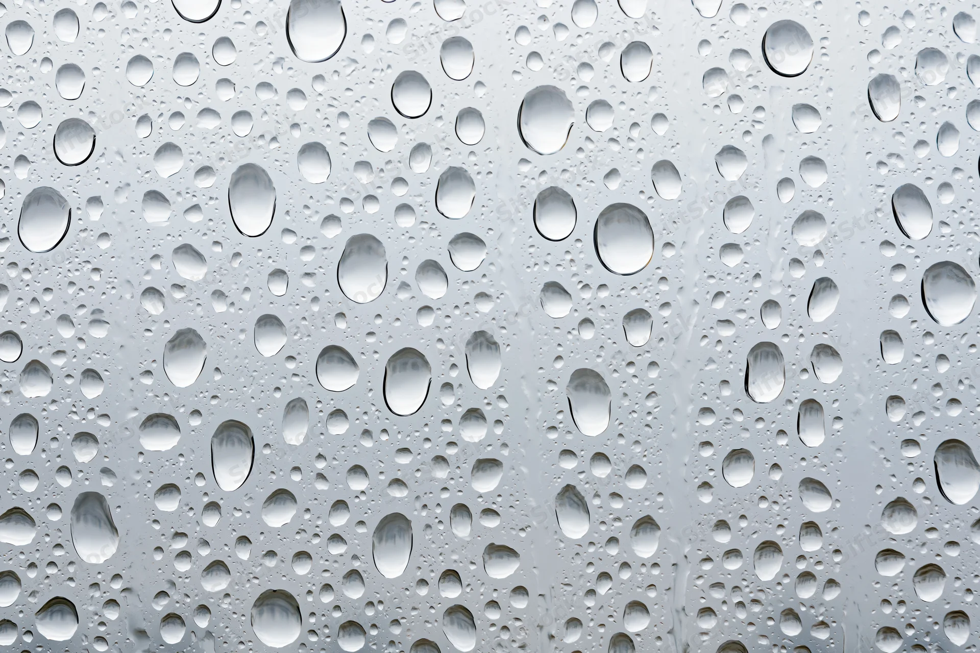 Water droplets clinging to a glass surface in a close-up macro view