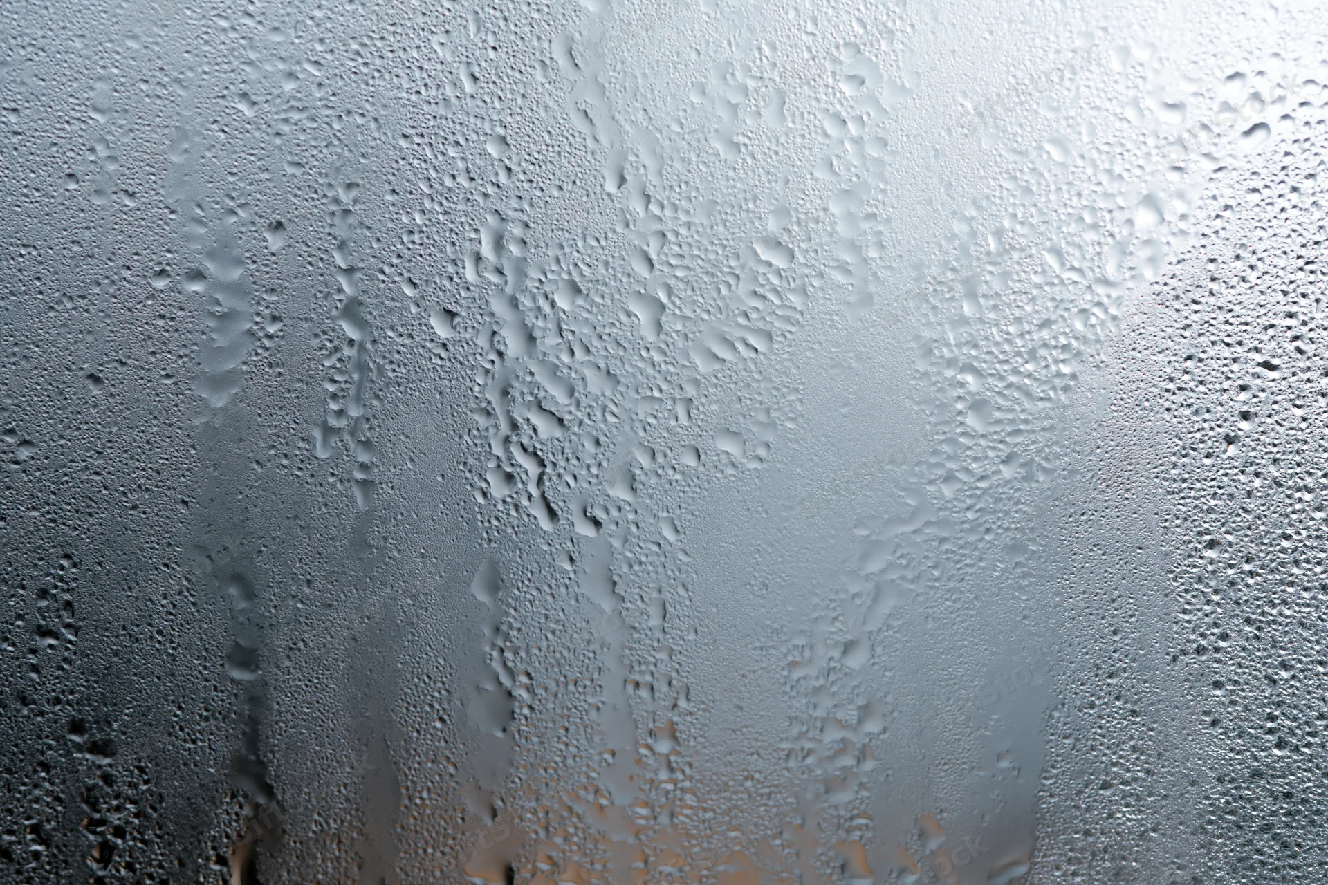 Fogged glass window covered in water droplets and condensation
