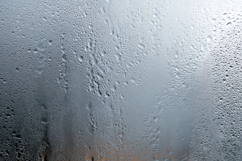 Fogged glass window covered in water droplets and condensation