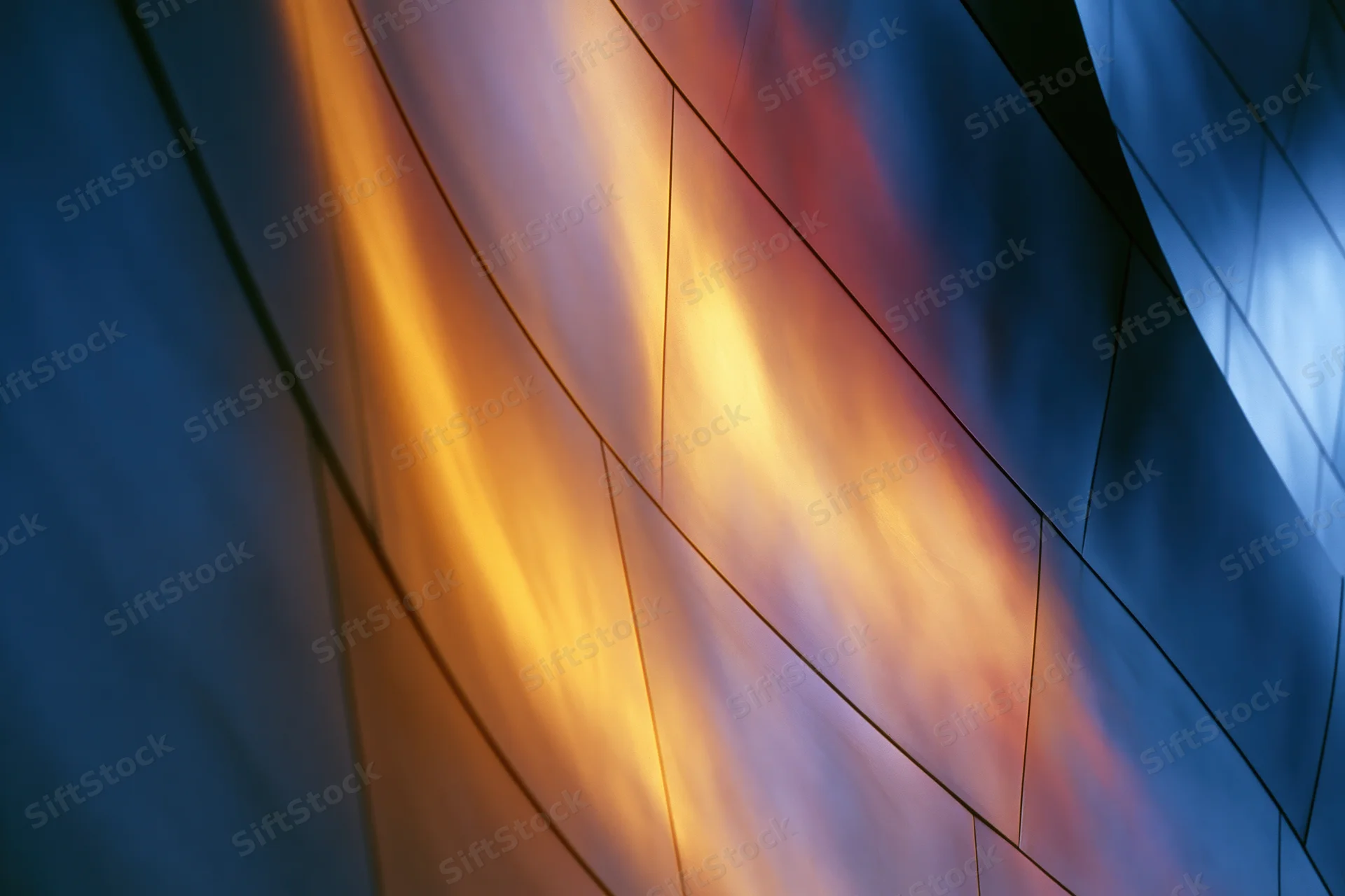Curved metal panels forming a modern architectural facade with colorful light reflections