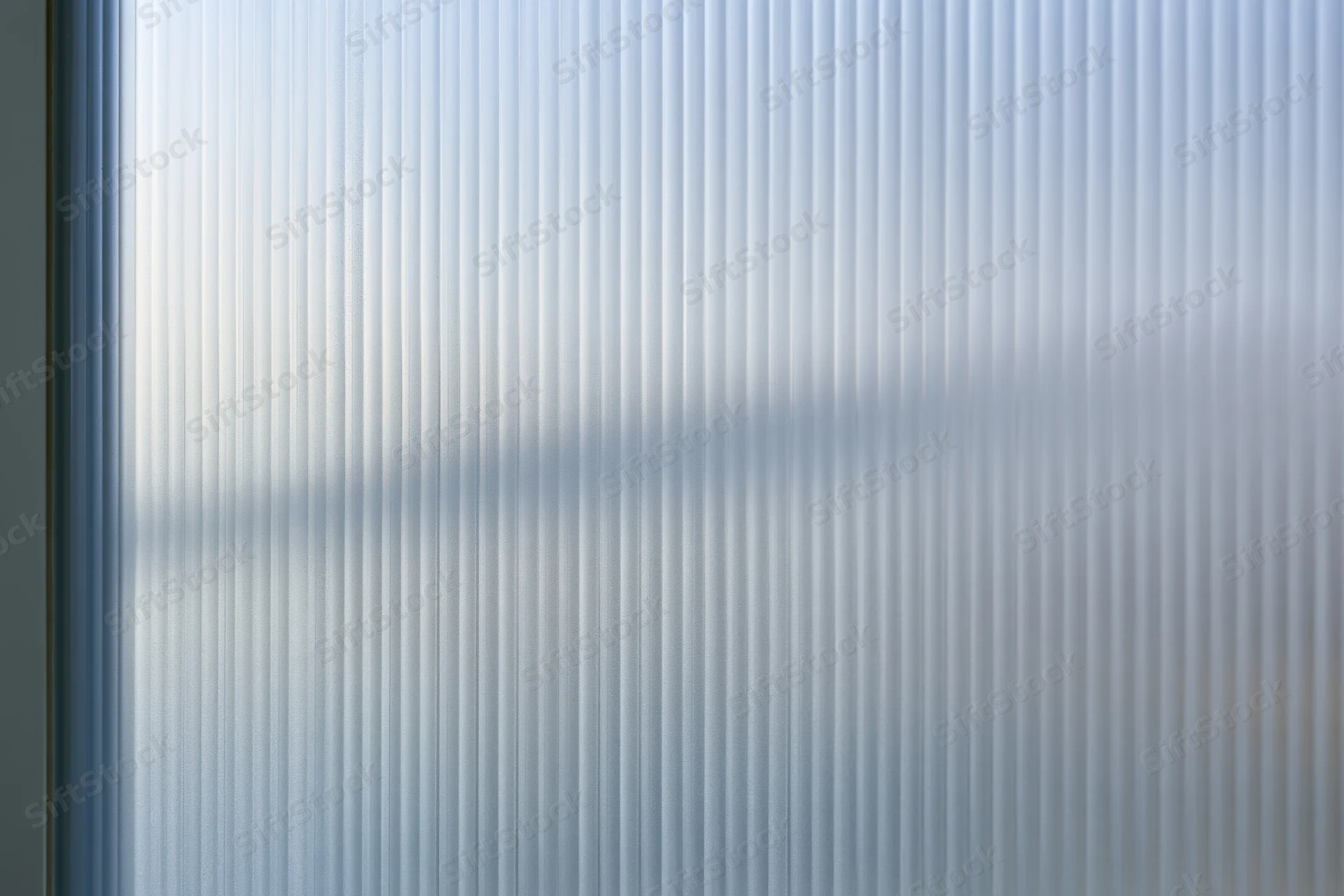 Ribbed frosted glass panel with vertical texture and diffused light patterns