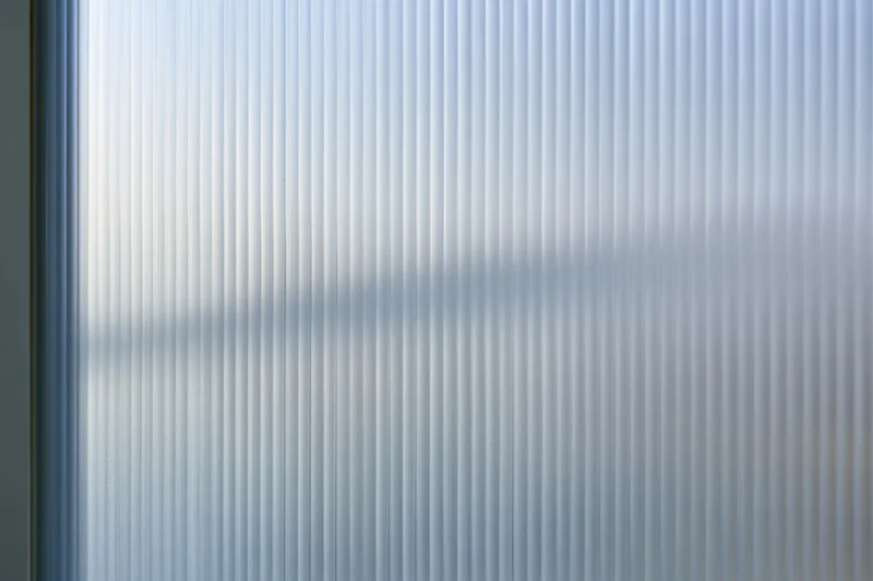 Ribbed frosted glass panel with vertical texture and diffused light patterns