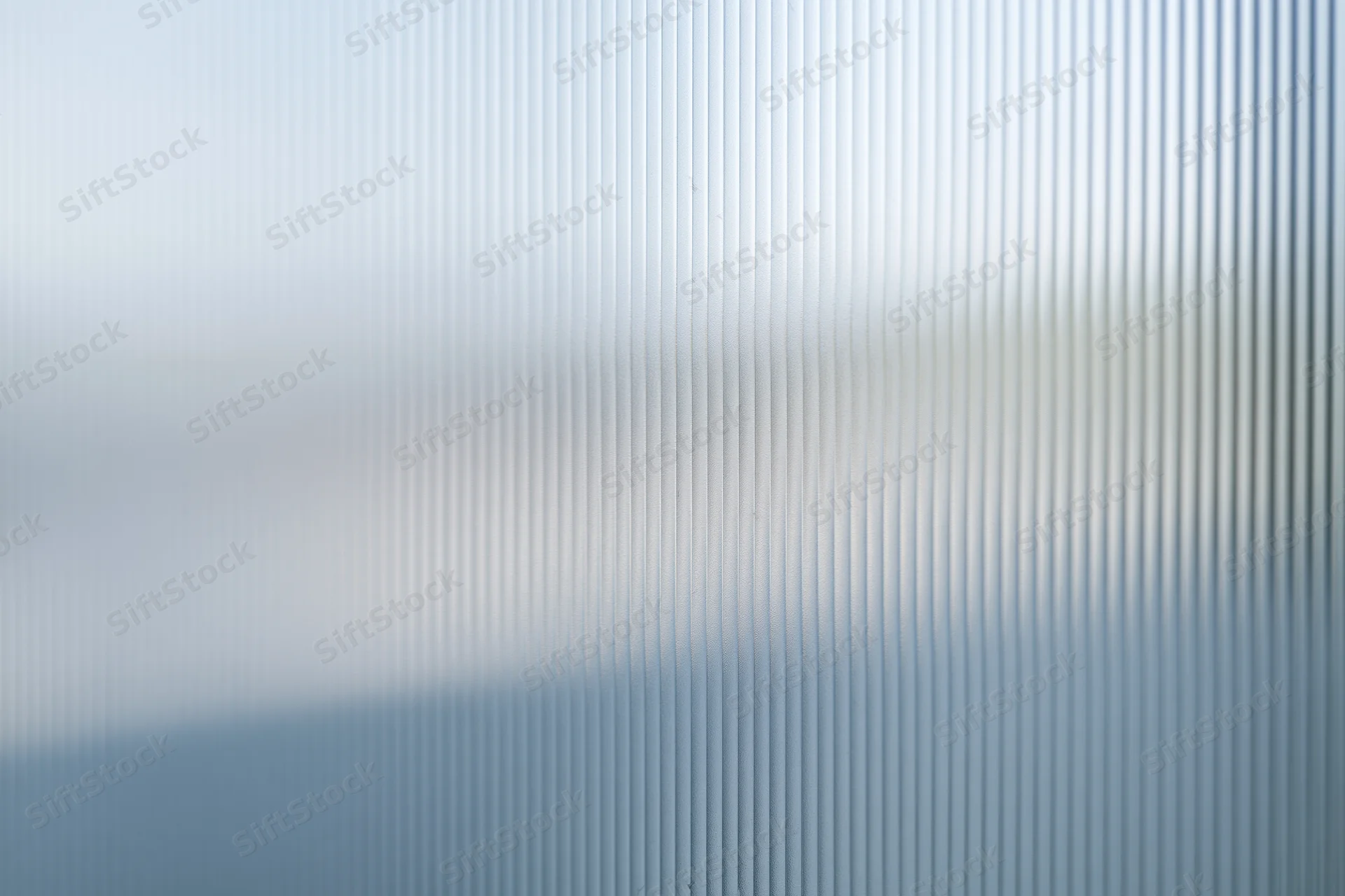 Close-up of ribbed frosted glass panel with vertical texture and diffused light