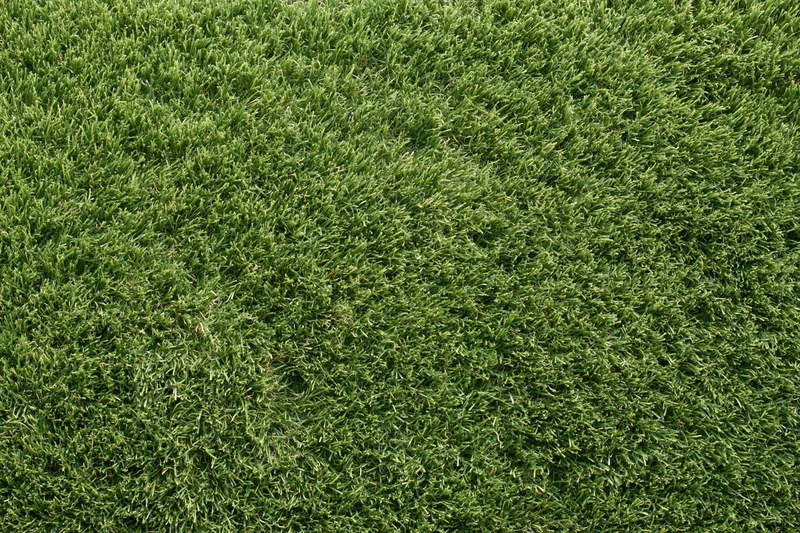 Close-up overhead view of uniformly trimmed artificial turf covering a flat surface