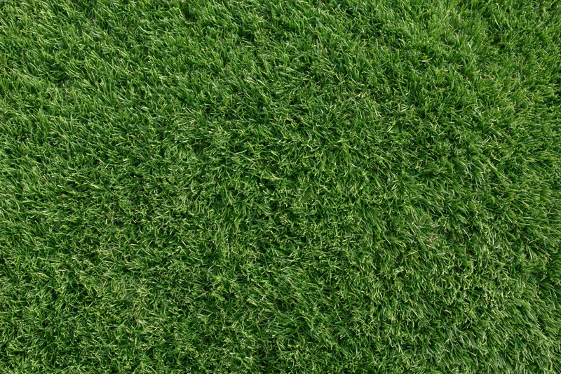 Close-up overhead view of uniformly trimmed artificial turf covering a flat outdoor surface