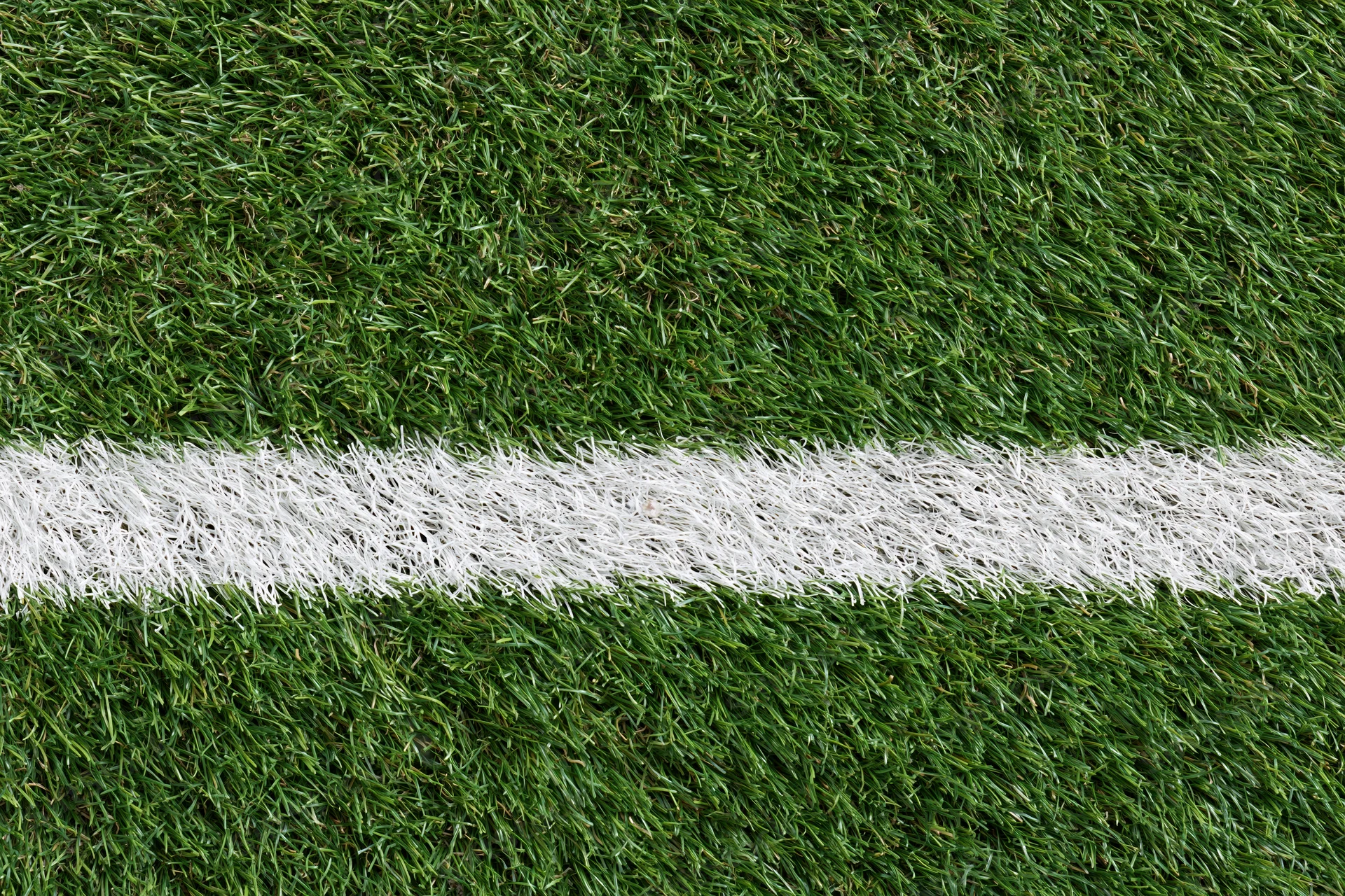 Artificial turf with white boundary line on sports field