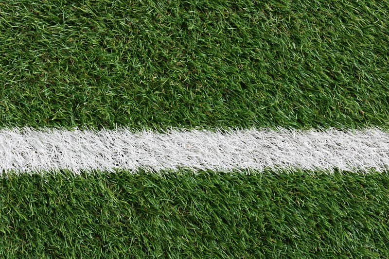 Artificial turf with white boundary line on sports field