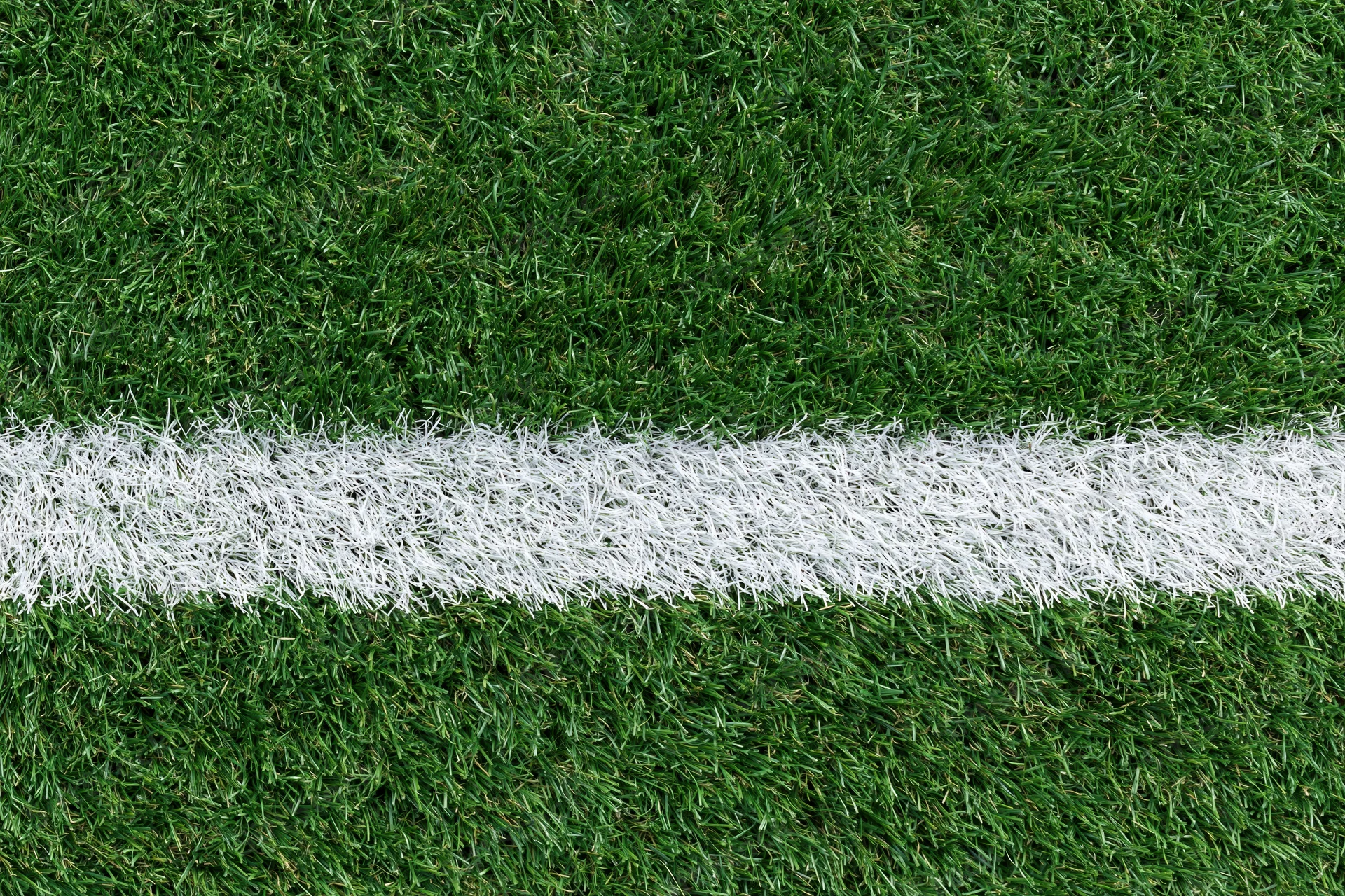 Artificial turf with white boundary line on sports field