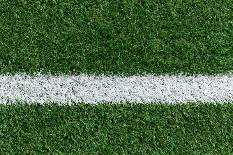 Artificial turf with white boundary line on sports field
