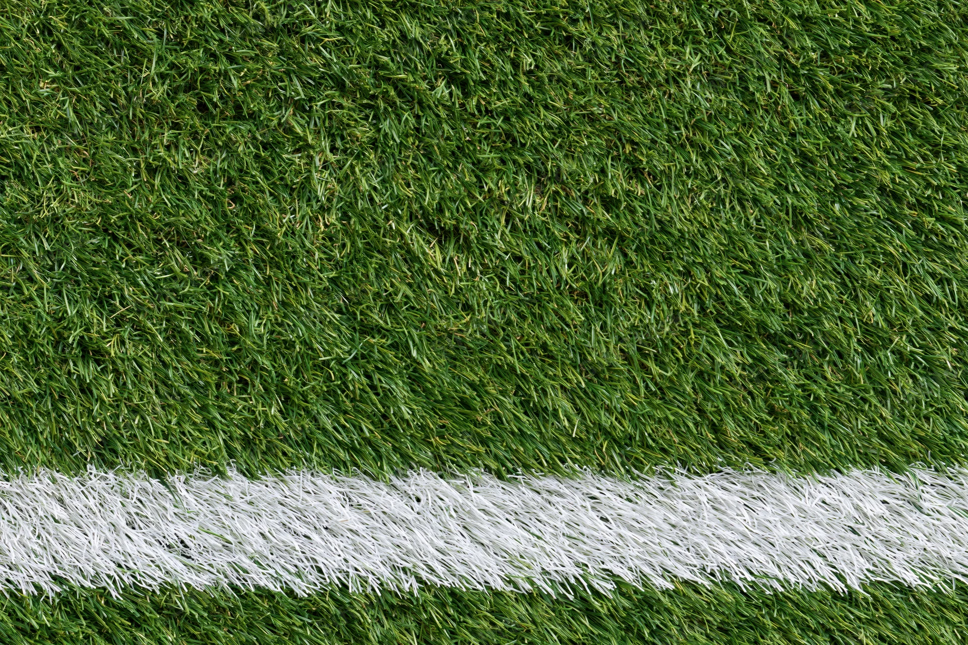 Artificial turf with white boundary line on sports field