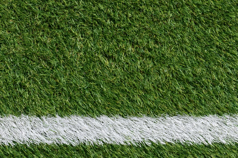Artificial turf with white boundary line on sports field