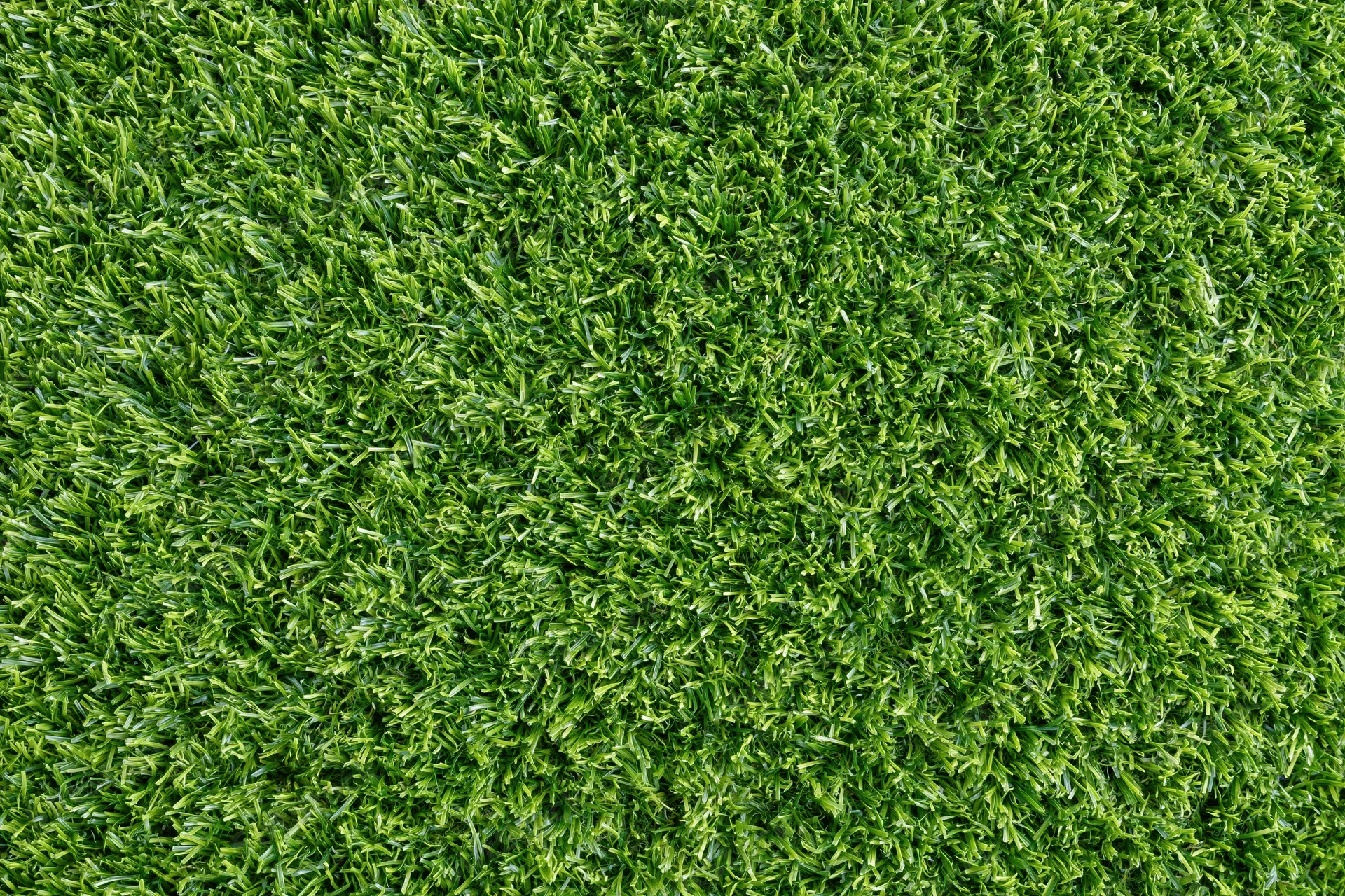 Dense short-cut artificial turf viewed from overhead, filling the frame as a uniform green surface