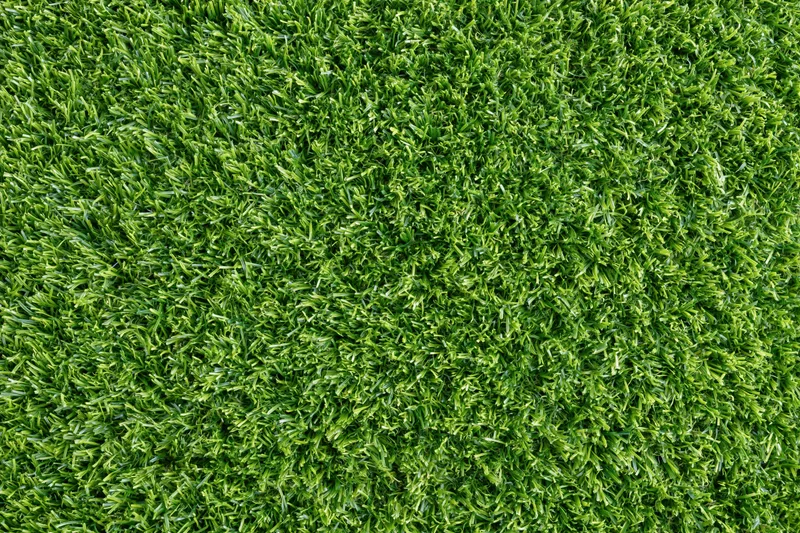 Dense short-cut artificial turf viewed from overhead, filling the frame as a uniform green surface